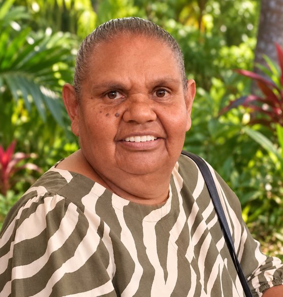 Debbie West, Wakka Wakka and Wulli Wulli woman, smiling in a tropical garden.
