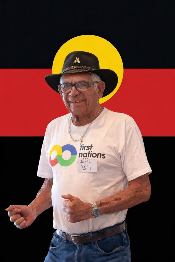 Uncle Bill Lemson, a respected First Nations Elder, photographed in his hat in front of the Aboriginal Flag.